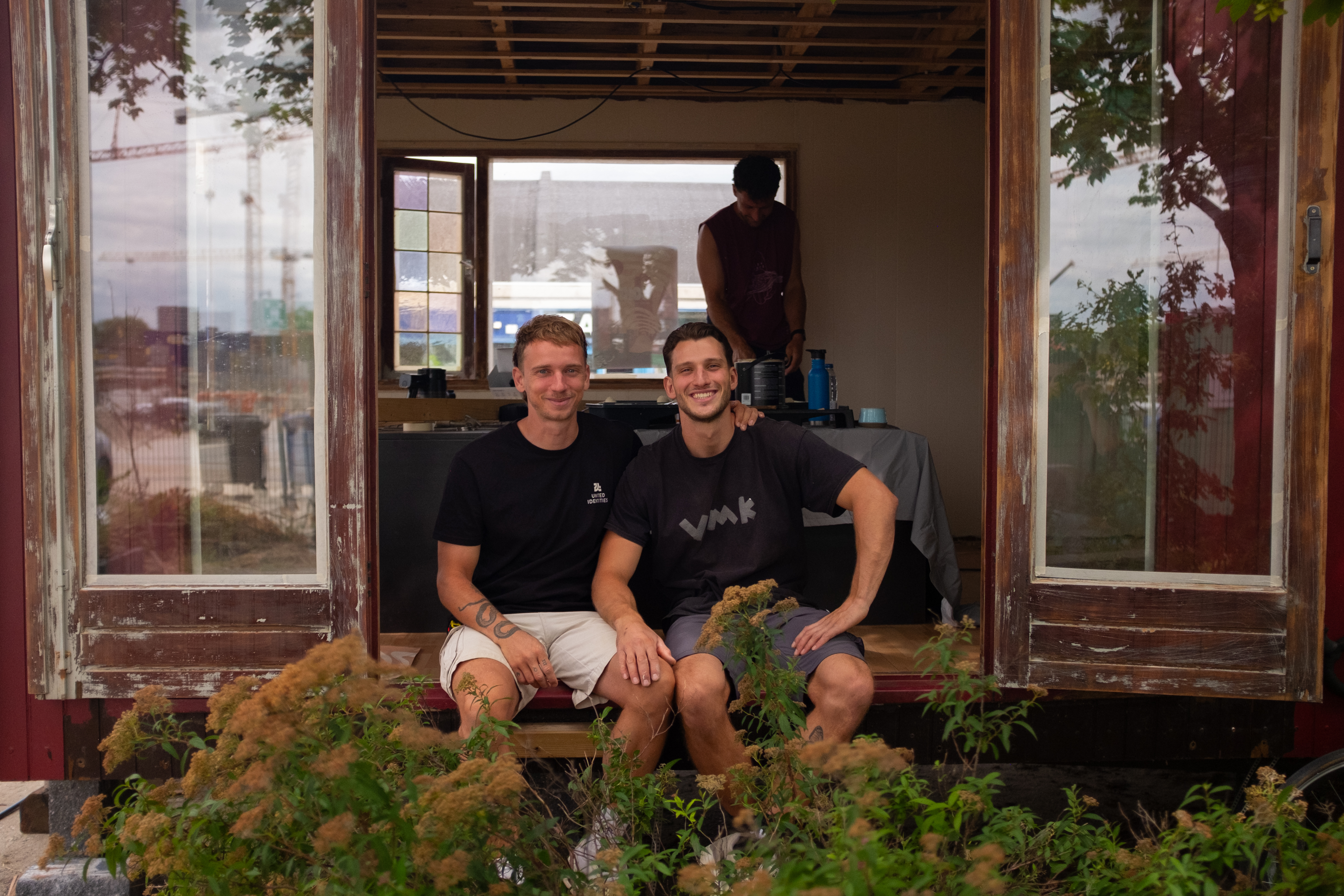 Luke and Tobias sitting on the chalet doorstep while SOKI is being built